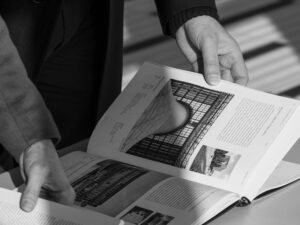 Consultazione del volume MCM Milano, Capitale del Moderno con fotografie di architettura del Moderno milanese